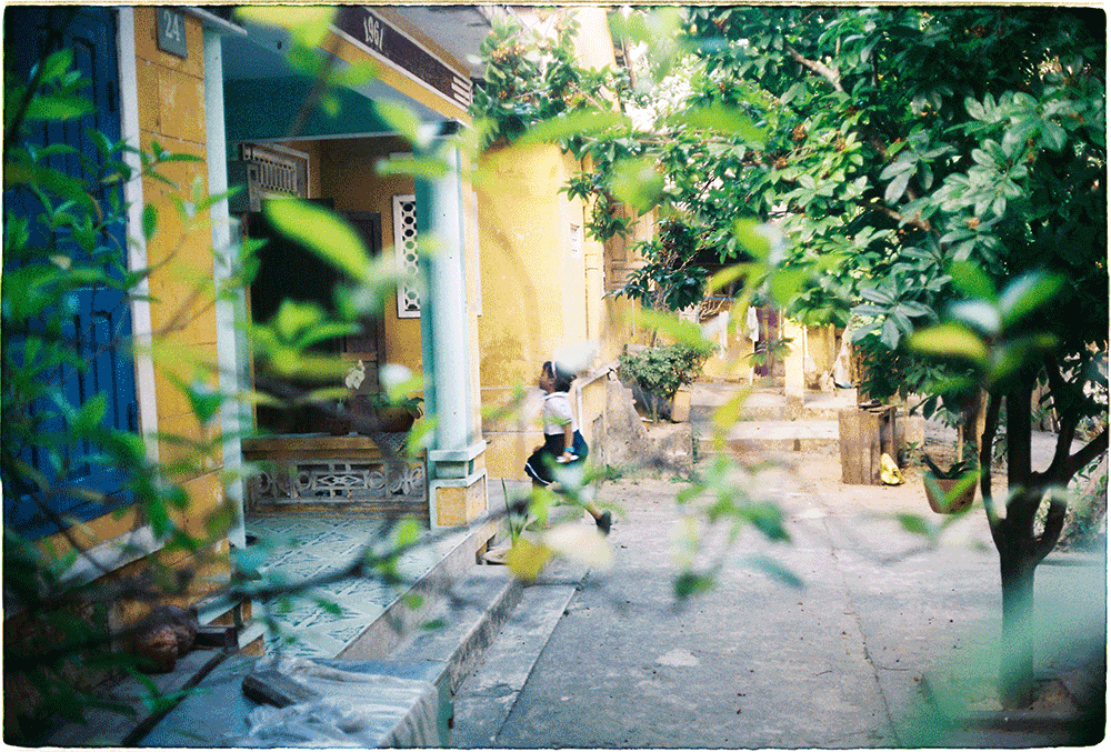 In the historic quarter of Hoi An, an elementary school girl hurries home.